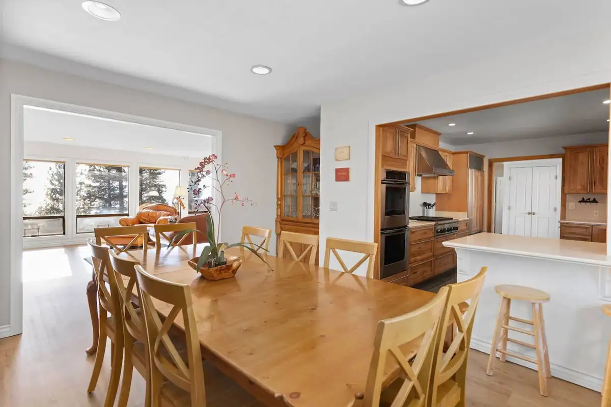 Dining table near a kitchen with island and wood cabinets, Tranquil Alpine Bliss
