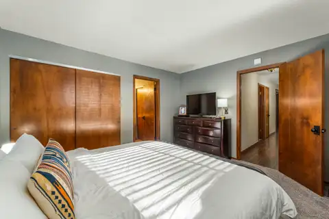 Bedroom with a bed, dresser and wood closet doors, Grand Regency Retreat