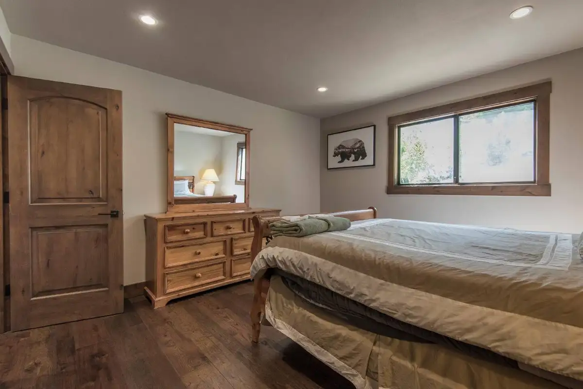 Bedroom with a bed, dresser and wood door, Tranquil Tahoe Haven
