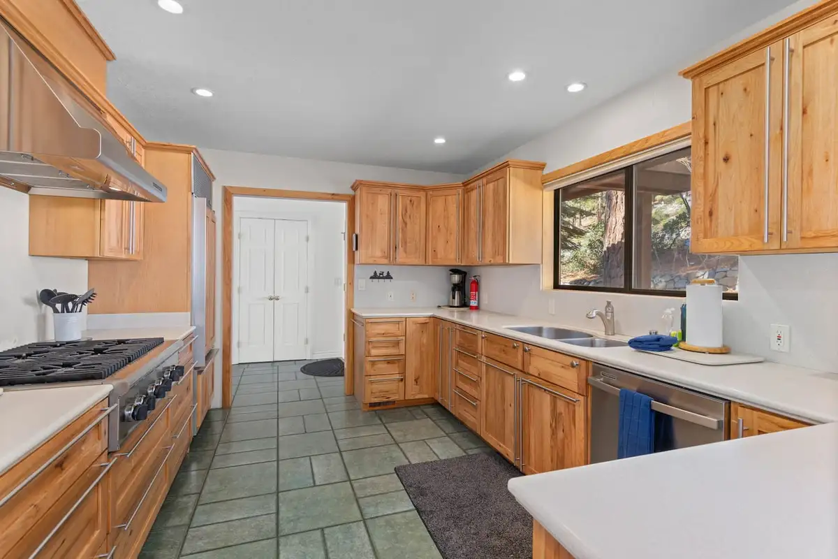 Kitchen with wood cabinets, gas cooktop and tile floor, Tranquil Alpine Bliss