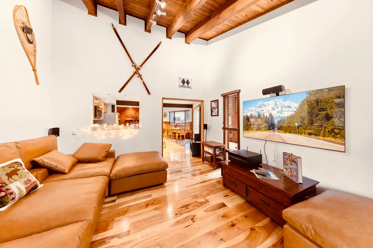 Living room with a leather sectional and mounted skis, Sunlit Incline Retreat