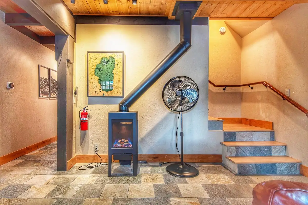 Living area with a black stove and stairs to the upper level, Restful North Ridge
