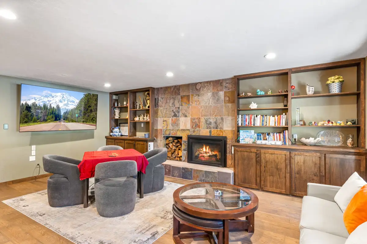 Sitting area with a fireplace, bookshelves and card table, Tranquil Stay