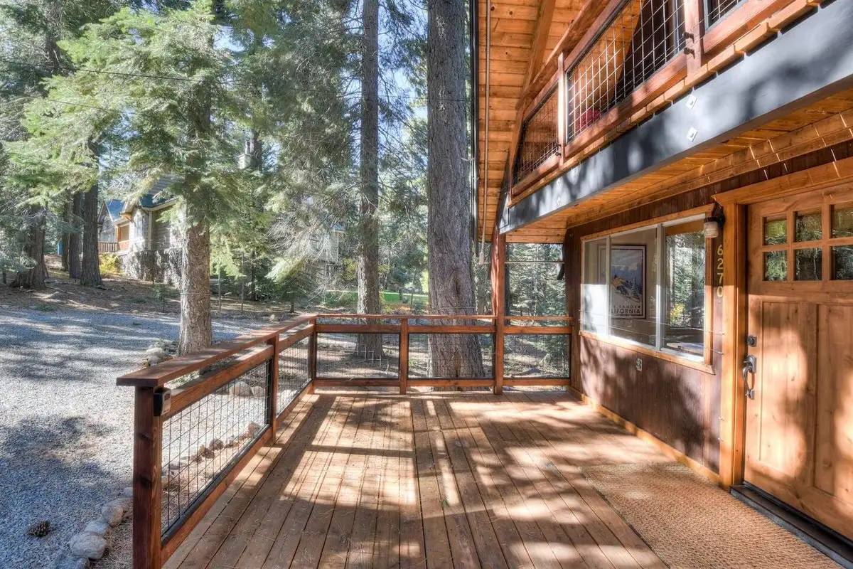 Wood deck with wire railing along the cabin front, Enchanting Chamberlands Cabin
