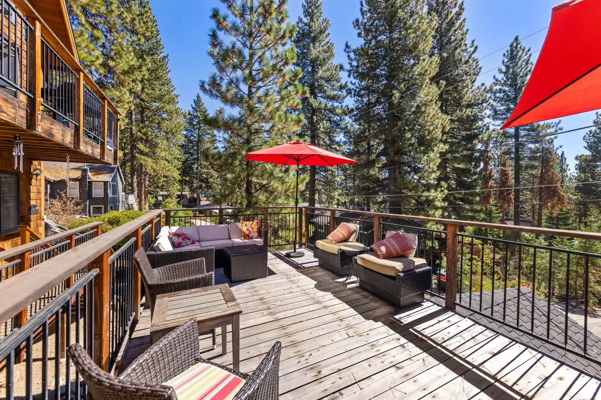 Deck with wicker seating and red umbrellas, Rustic Ridge Retreat
