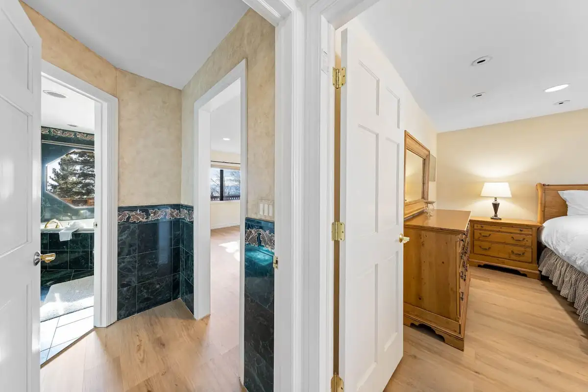Hallway leading to a bedroom and marble-tiled bathroom, Tranquil Alpine Bliss