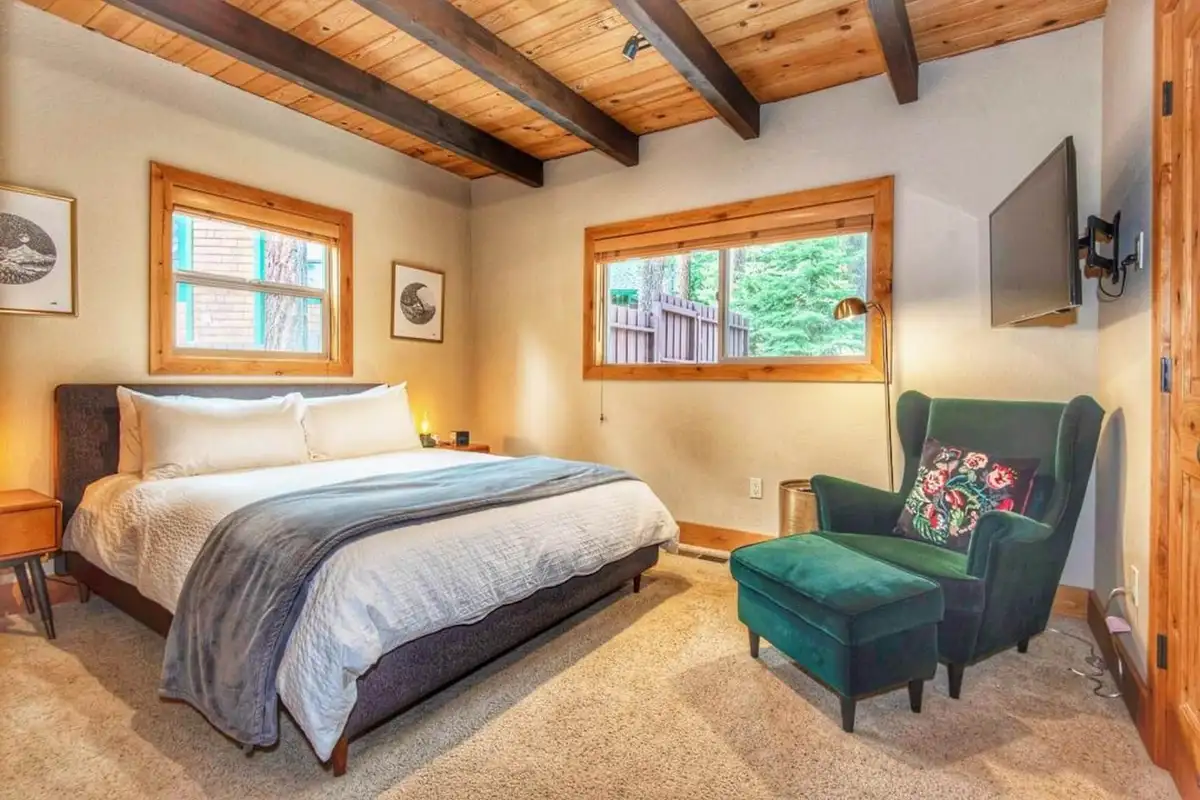 Bedroom with a bed, green armchair and ottoman, Restful North Ridge