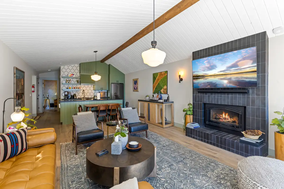 Living room with tiled fireplace and kitchen beyond, Lakeside Luxe Retreat