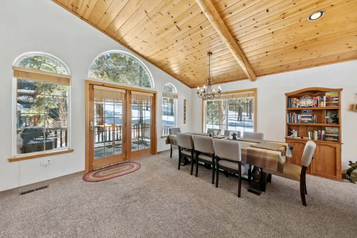 Dining area with arched windows and a wood bookcase, Hastings Hideaway Cabin
