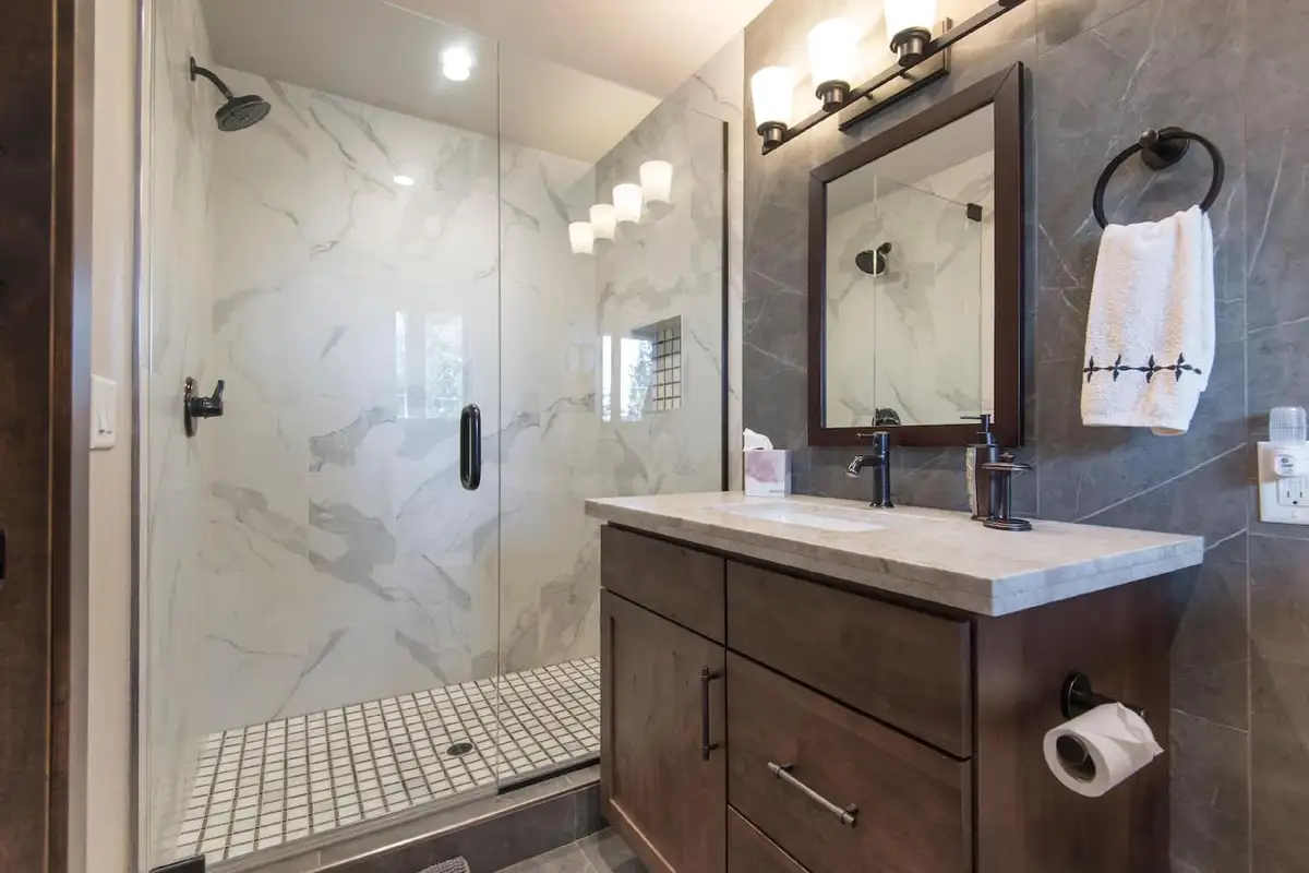 Bathroom with a marble walk-in shower and wood vanity, Tranquil Tahoe Haven