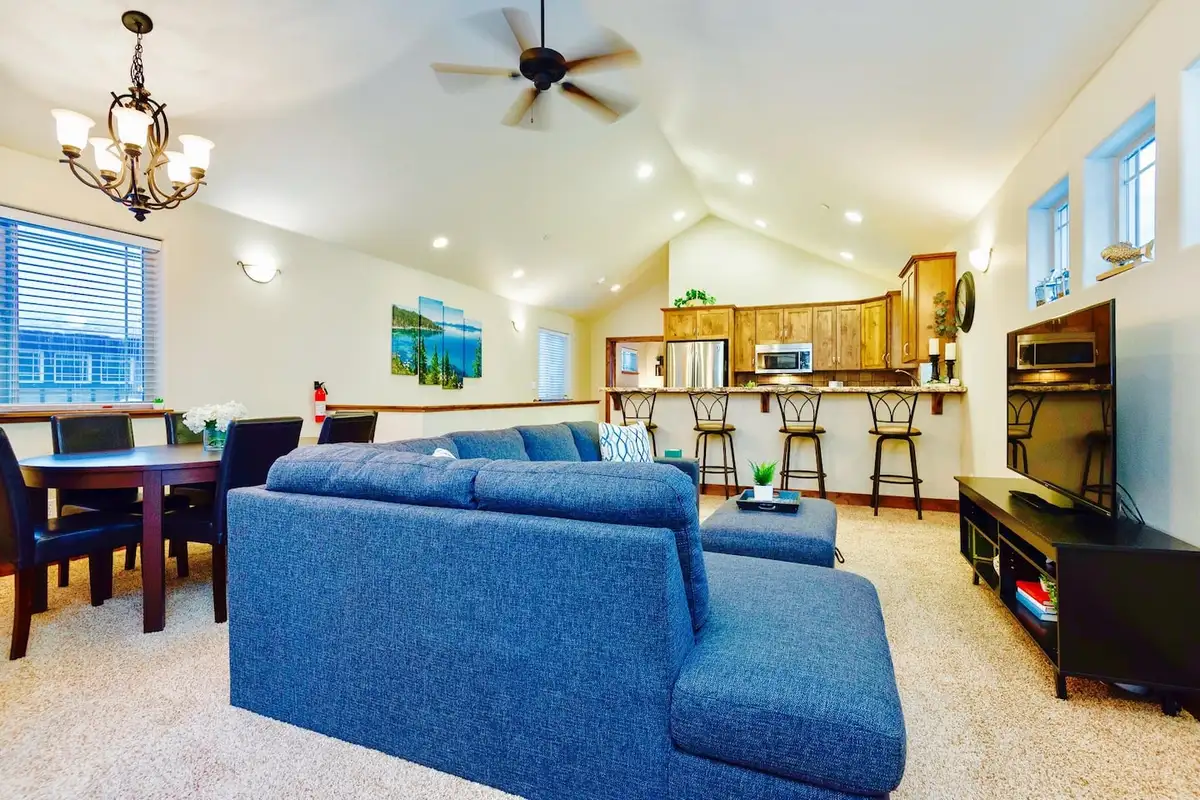 Living room with a gray sectional sofa and vaulted ceiling, Trout and About