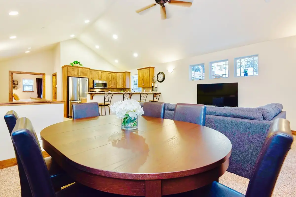 Round dining table with the kitchen and living room beyond, Trout and About