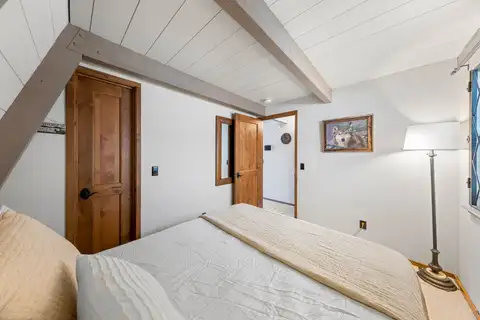 A-frame bedroom with a bed and floor lamp, Livin' on the Edge
