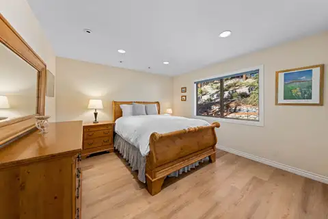 Bedroom with a wood sleigh bed and dresser mirror, Tranquil Alpine Bliss