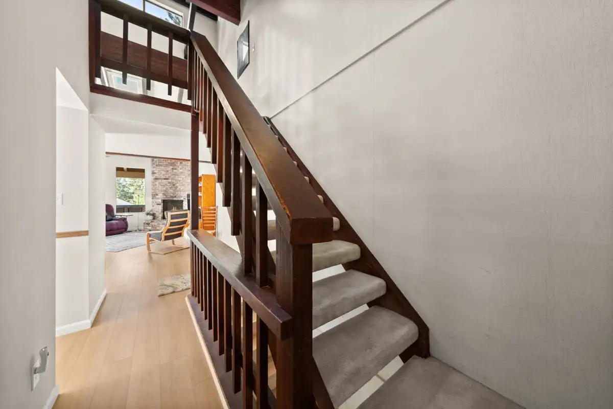 Staircase with wooden railing leading to the living area, Skiway Suite