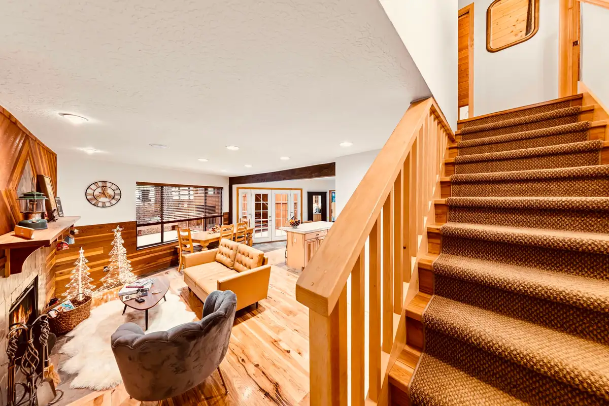 Carpeted staircase beside a living area with fireplace, Sunlit Incline Retreat