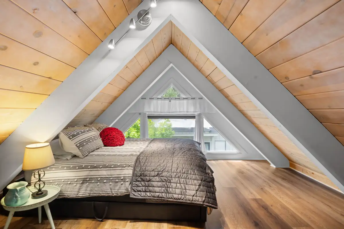 A-frame loft bedroom with a bed under a wood-paneled ceiling, Tahoe Peaks & Shores Retreat