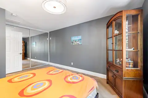 Bedroom with mirrored closet doors and a wood display cabinet, Tranquil Stay