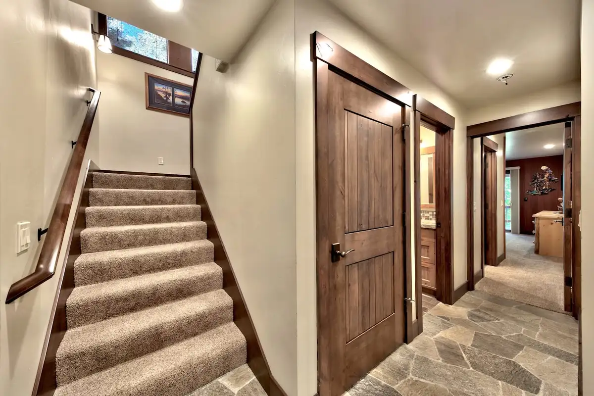 Carpeted staircase and slate hallway with wood doors, Mammoth Haven Retreat