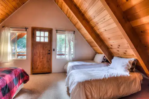A-frame bedroom with twin beds and wood-paneled ceiling, Enchanting Chamberlands Cabin
