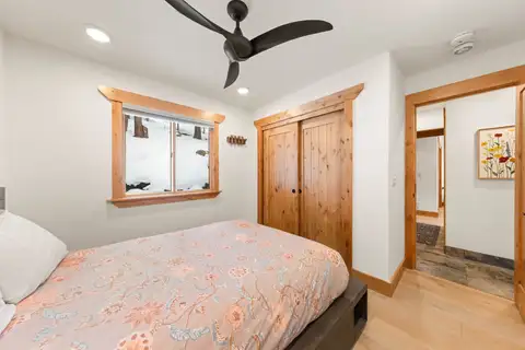 Bedroom with a floral bed and wood closet doors, Sugar Pine Tahoe Lodge