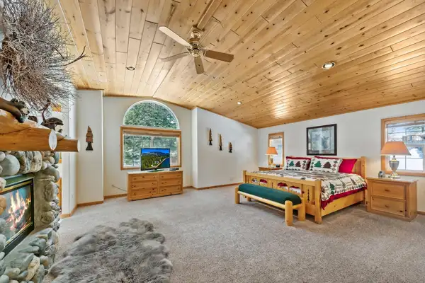 Bedroom with wood ceiling, stone fireplace and log bed, Hastings Hideaway Cabin