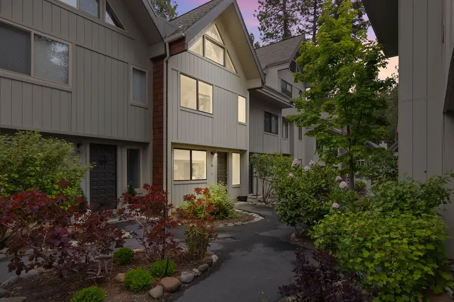 Gray townhouse exterior with a landscaped walkway and shrubs, Tahoe Peaks & Shores Retreat