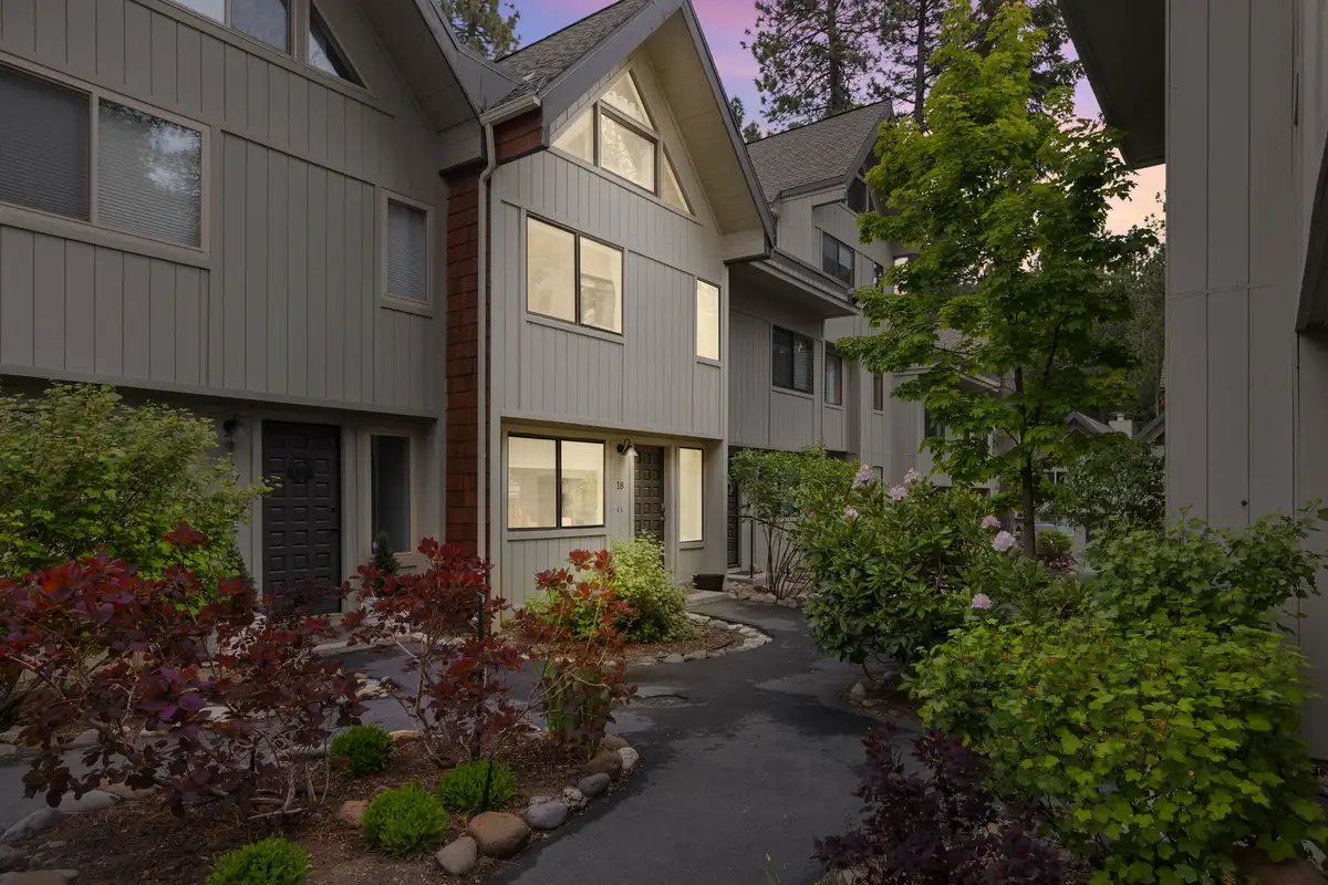 Gray townhouse exterior with a landscaped walkway and shrubs, Tahoe Peaks & Shores Retreat