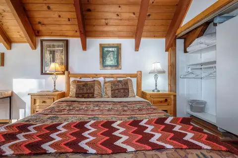 Bedroom with a log bed and chevron blanket, Lakeview Serenity Cottage