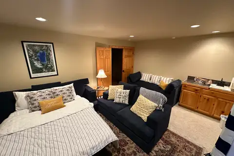 Room with a bed and a dark loveseat, Lakeview Grandeur