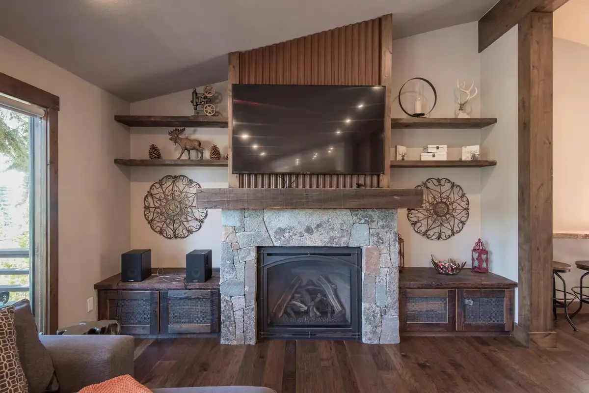 Stone fireplace with TV above and floating shelves, Tranquil Tahoe Haven