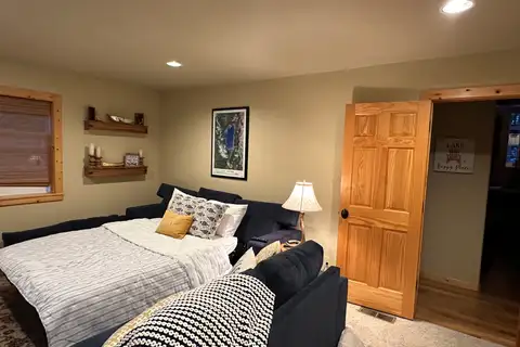Room with a bed, loveseat and wood door, Lakeview Grandeur