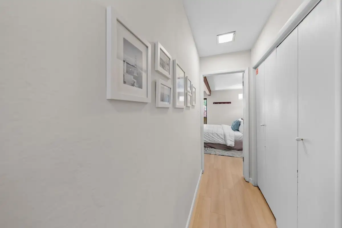 Hallway with framed photos leading to a bedroom, Skiway Suite