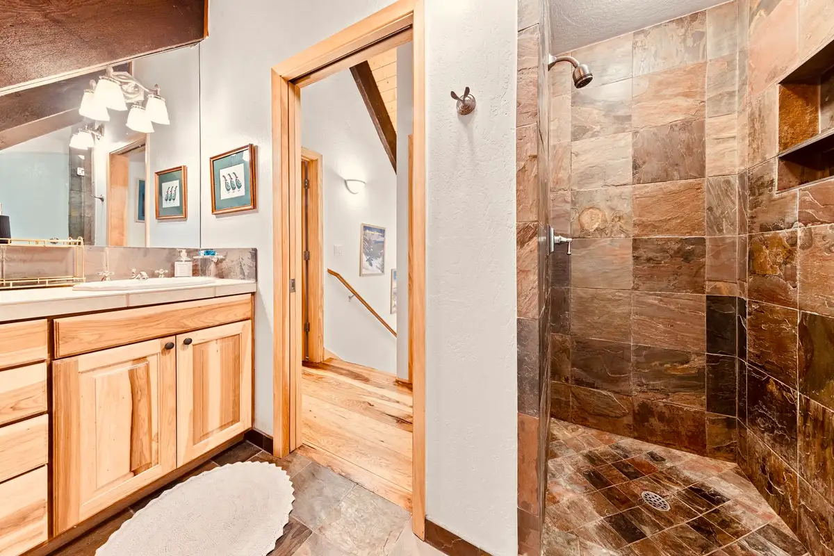 Bathroom with wood vanity and slate-tiled shower, Sunlit Incline Retreat