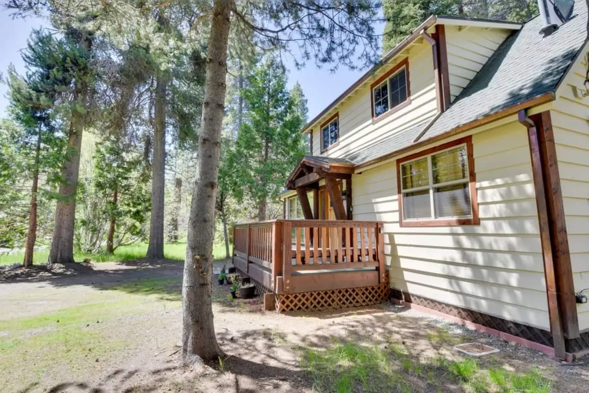 Side of a cabin with a small deck among pines, Tranquil Trails Cabin