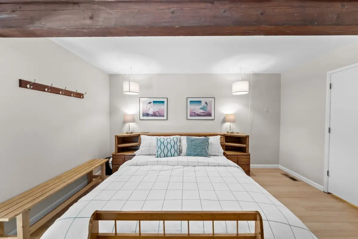 Bedroom with a bed and wooden bench, Skiway Suite