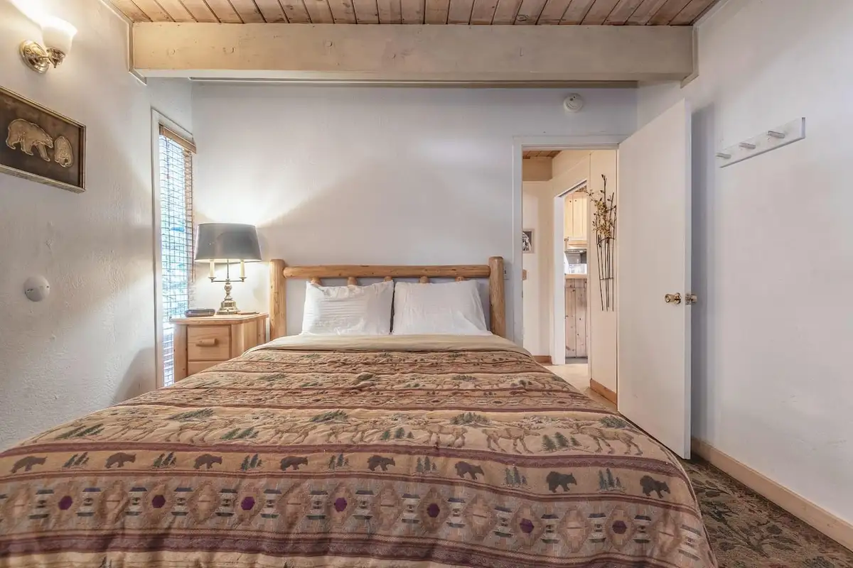 Bedroom with a log bed and patterned bedding, Lakeview Serenity Cottage