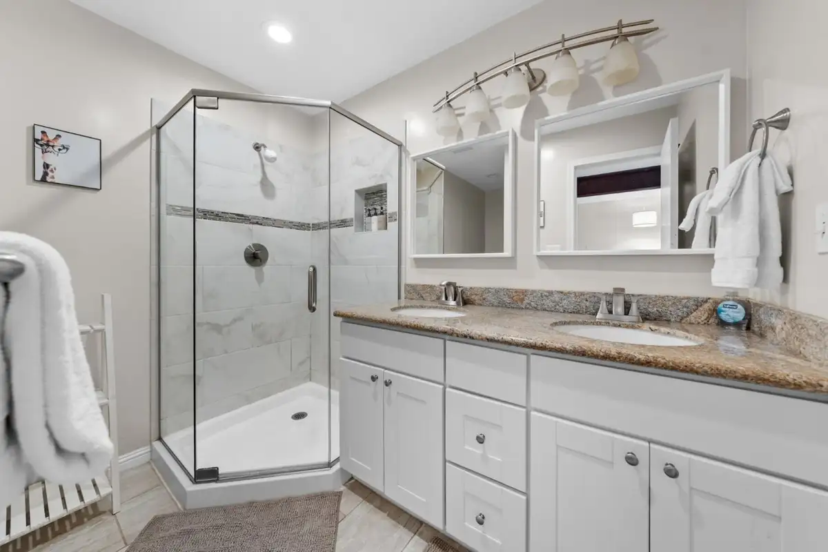 Bathroom with a corner glass shower and double vanity, Skiway Suite