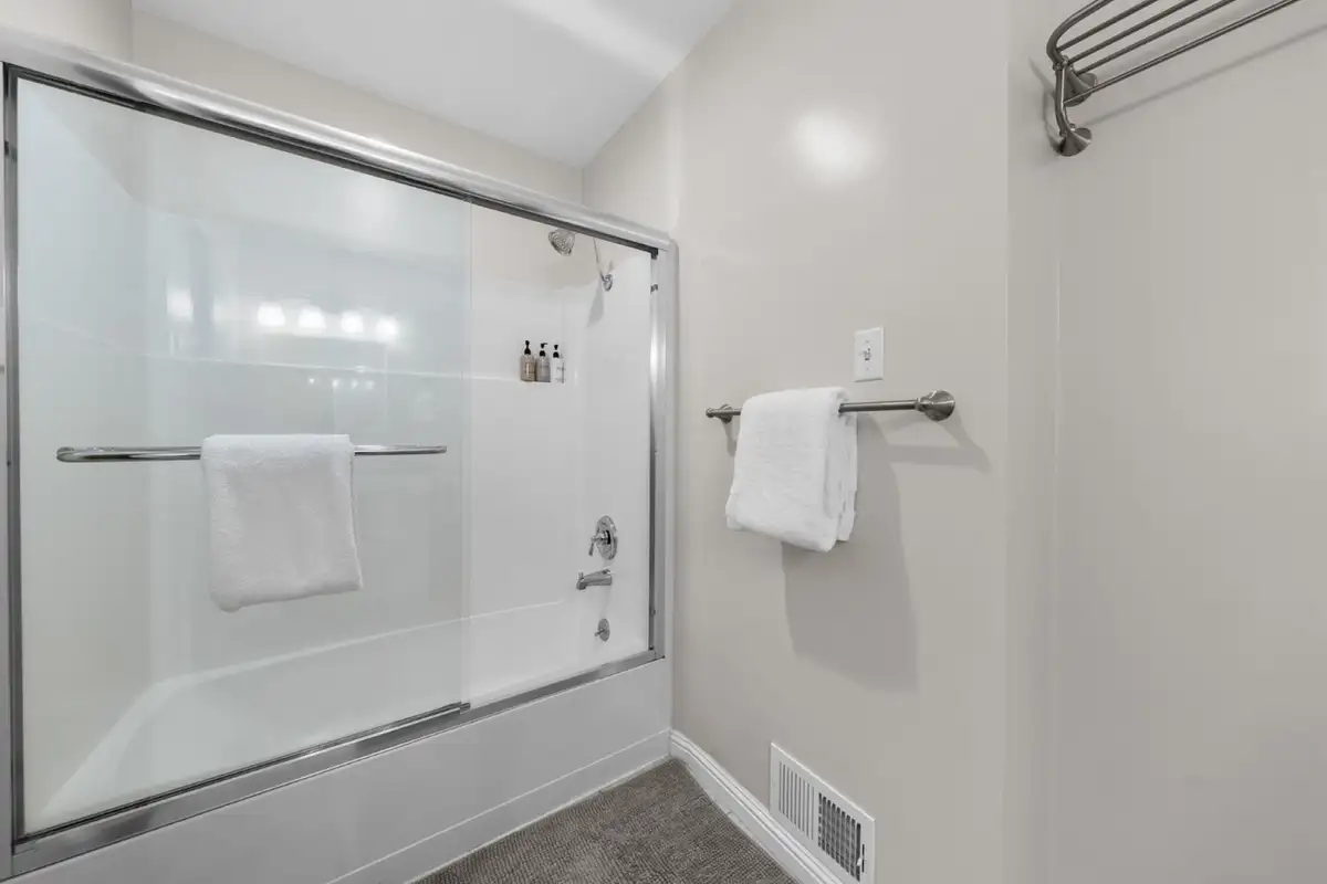 Bathroom with a glass-door tub and shower, Skiway Suite