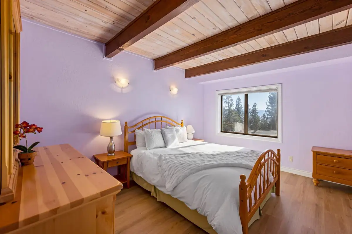 Lavender bedroom with a bed and beamed wood ceiling, Tranquil Alpine Bliss
