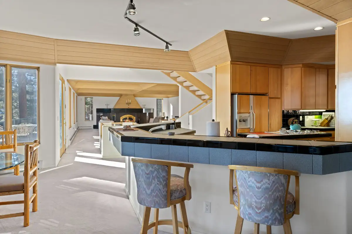 Kitchen bar with stools and open living area beyond, 90s Tahoe Time Capsule
