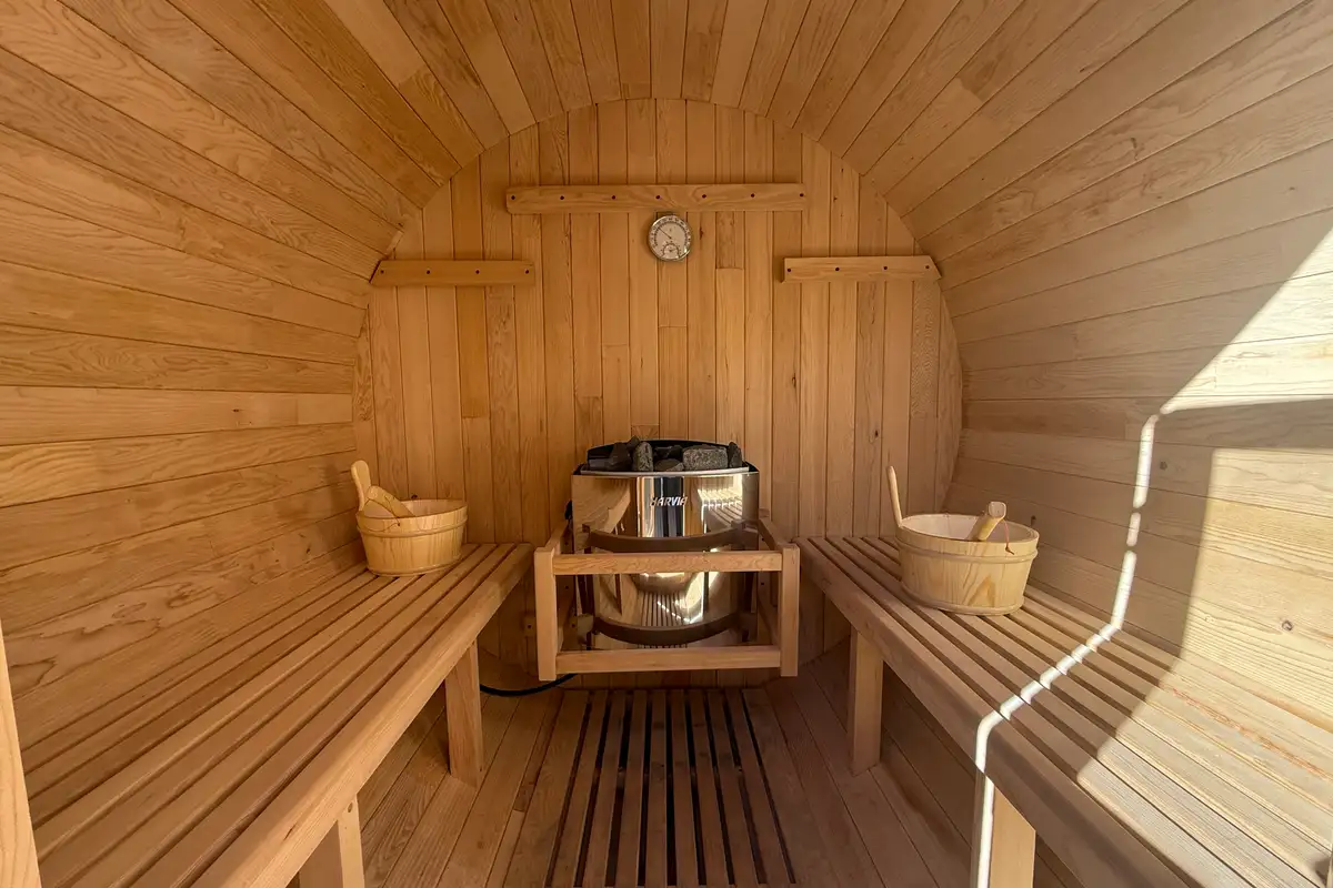Barrel sauna interior with wood benches and heater, Lakeview Oasis