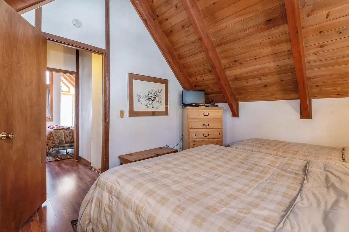 Bedroom with a bed under a sloped wood ceiling, Lakeview Serenity Cottage