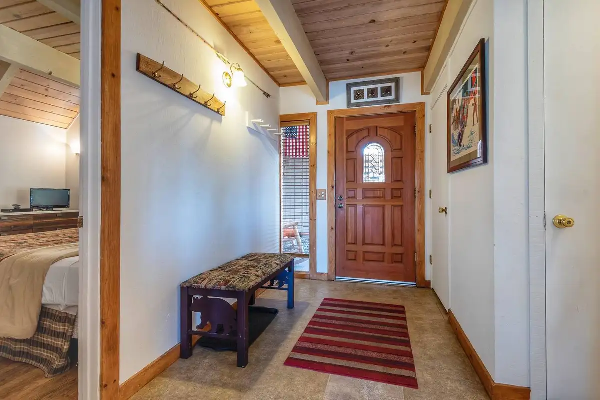 Entry hall with a wood front door and a bench, Lakeview Serenity Cottage