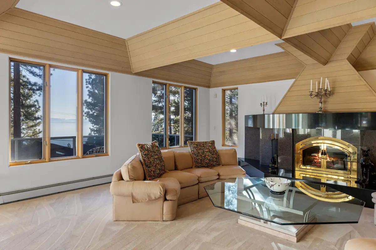 Living room with fireplace and Lake Tahoe visible through the windows, 90s Tahoe Time Capsule